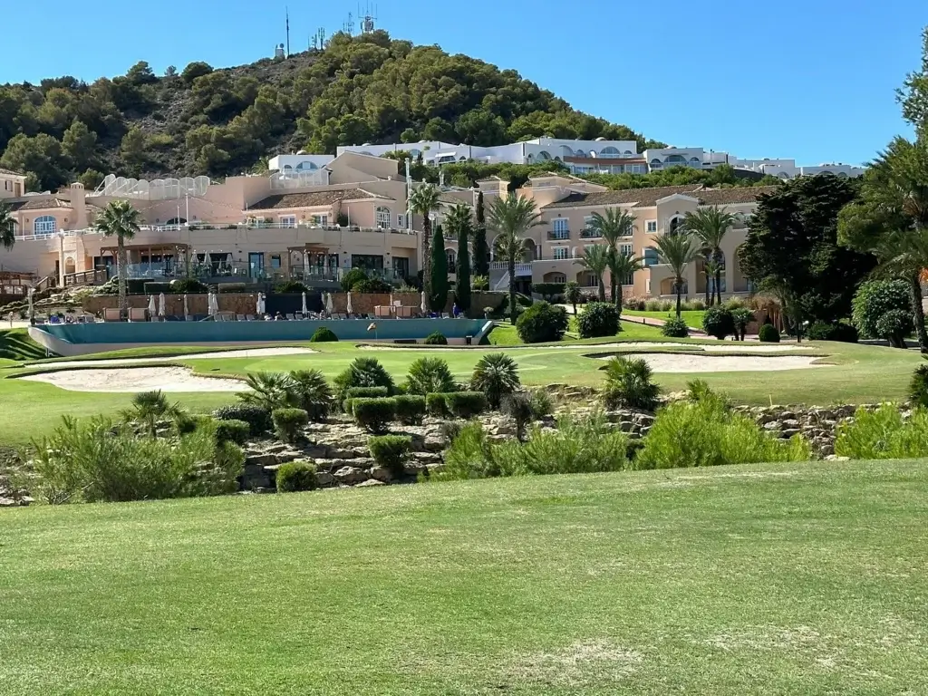 a golf course with a large building and trees